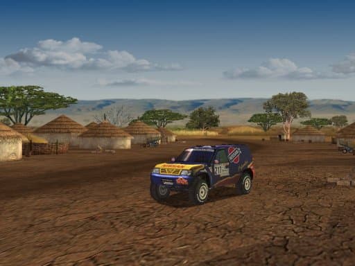 Front three-quarter view of a Nissan rally vehicle in a village clearing with thatched huts